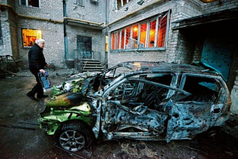 A man stands next to his car after it was destroyed by shelling today in the rebel-controlled city of Donetsk on Sunday.