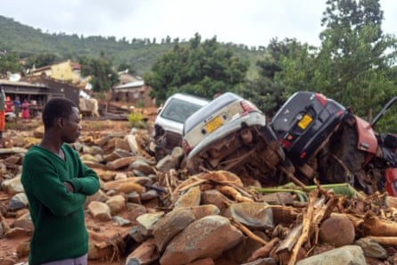 A man stands near the wreckage of vehicles washed away by Cyclone Idai in Chimanimani, eastern Zimbabwe, in March 2019