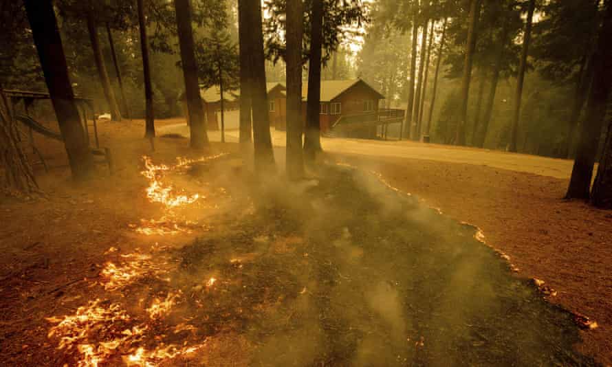 Flames from the Caldor Fire scorch the ground near a structure in Grizzly Flats, California, on Wednesday.