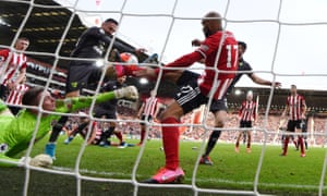 Dean Henderson, izquierda, lucha por mantener el balón en la victoria de Sheffield United sobre Norwich.