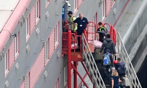 People carrying bags walking up the gangway into the Bibby Stockholm accommodation barge, at the quayside at Portland Port in Portland