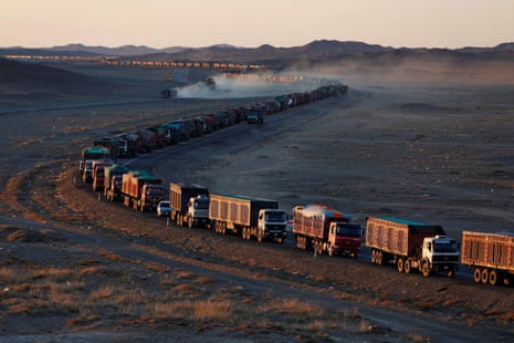 Thousands of heavy-duty trucks loaded with coal travelling along the sole road on the Mongolia-China border in the Gobi desert in 2017. The journey can take more than a week