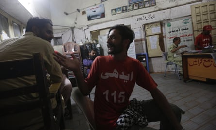 Safdar chats with his colleague at the Edhi Foundation office in Karachi.