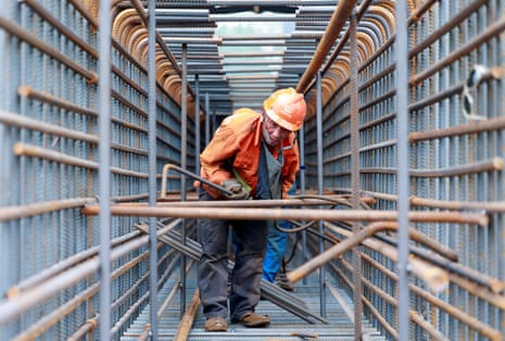 A worker prepares steel bars on a construction site