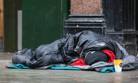 A homeless person is seen on a pavement in London.