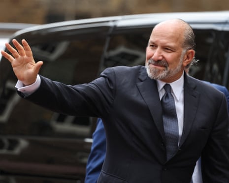 Howard Lutnick waves as he walks away from a car