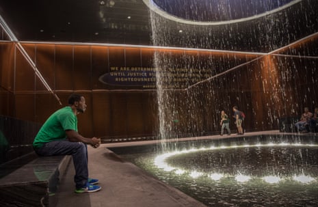 man sits on bench and looks ahead at fountain in thought