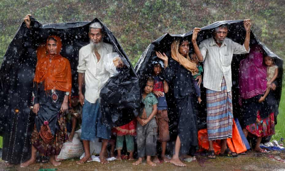Rohingya refugees shelter from the rain in a camp in Cox’s Bazar, Bangladesh, on Sunday