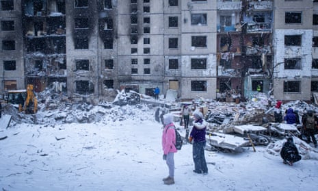 People stand in the courtyard of a residential apartment building damaged in a Russian missile attack on Wednesday in Kyiv, Ukraine