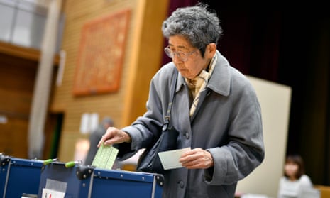 A woman casts her vote in Japan’s general election. Shinzo Abe’s ruling Liberal Democratic party is expected to win more than 300 of the 465 seats. 