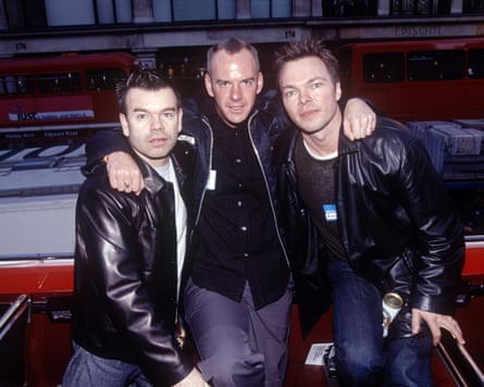 Norman Cook (Fatboy Slim), arms over the shoulders of Paul Oakenfold and Pete Tong, all wearing black leather jackets