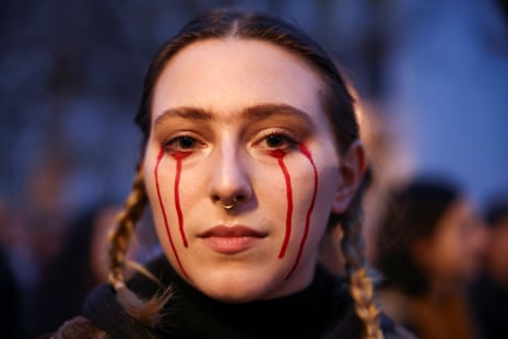 A woman protestor with eye make-up made to look like blood at a vigil for Alexei Navalny in Berlin, Germany.