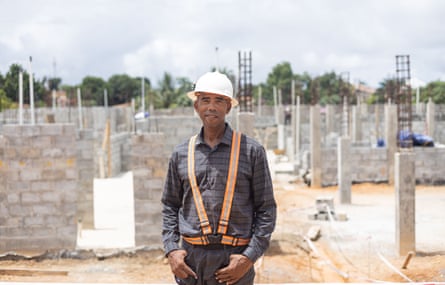 A man in a hard hat stands among the foundations of the new maternity unit