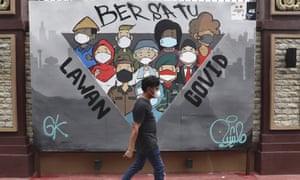 Coronavirus news live: South Korea reports daily Covid case record as Omicron variant hits 4 A man walks past a coronavirus-themed mural in Jakarta, Indonesia, as the country tightens travel curbs in preparation for Omicron arrival.