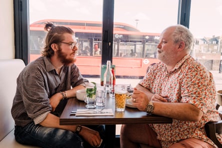 Two men facing each other across a restaurant table