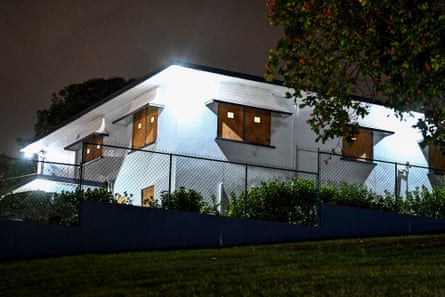 white house with boards in windows