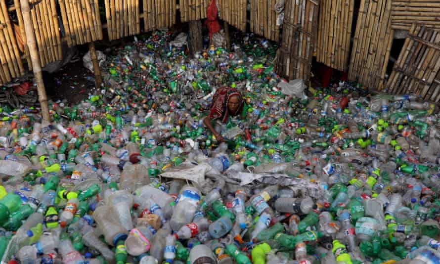 A woman works in a plastic bottle recycling factory in Dhaka, Bangladesh.