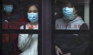 Commuters wearing face masks to help curb the spread of the coronavirus look out from a traveling bus during the morning rush hour in Beijing, Monday, 26 October, 2020.