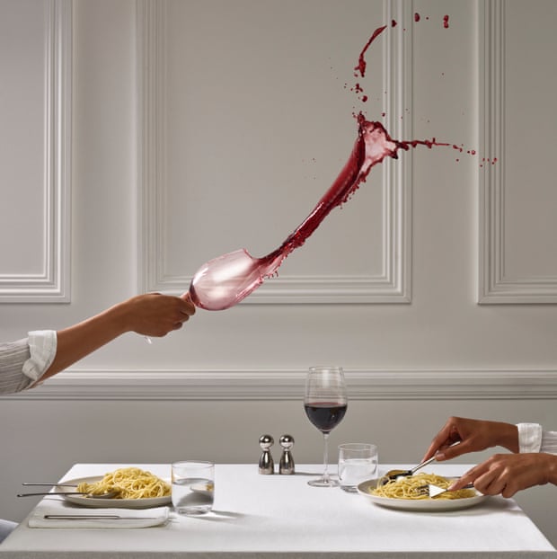 Photograph of someone throwing a glass of wine at someone else over dinner