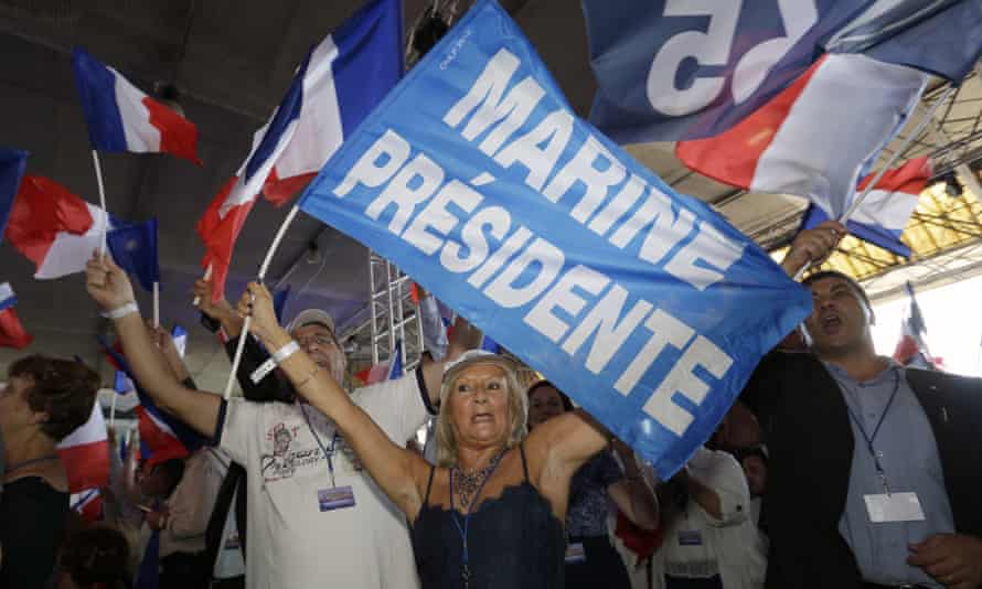 Supporters of Le Pen wave flags during the summer conference.