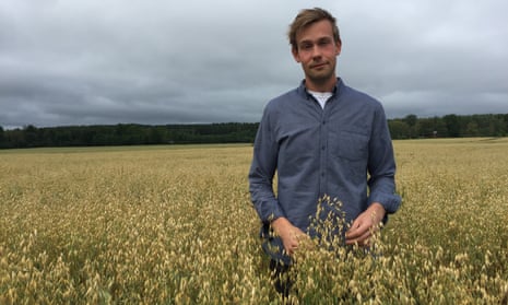 Adam Arnesson in a field of oats at his organic farm in Örebro country, Sweden
