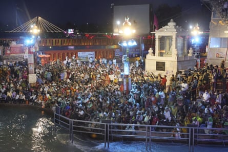 Devotees sit and pray in the evening on the ghats of the Ganges on 12 April