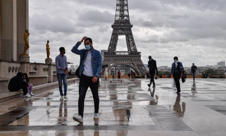 People wear medical masks near the Eiffel Tower in Paris, France