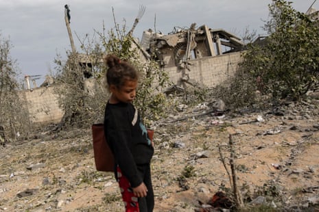A displaced Palestinian child looks on a she stands near the Abu Nuqira family home destroyed after an Israeli air strike in the Rafah refugee camp, 26 March.