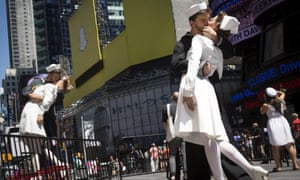 Actors reenact the famous picture of a sailor kissing a nurse on the 70th anniversary of Victory over Japan Day, near a replica sculpture in New York's Times Square August 14, 2015. The replica is being displayed to celebrate the 70th anniversary of the iconic photograph of the most famous kiss in American history that was captured between an American sailor and nurse on August 14, 1945, marking the end of World War Two. The actors are hired by a tour bus company to pose for groups to photograph.  REUTERS/Brendan McDermid       TPX IMAGES OF THE DAY