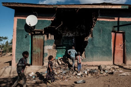 Children play in a damaged house in Bisober, where a massacre took place in 2020.
