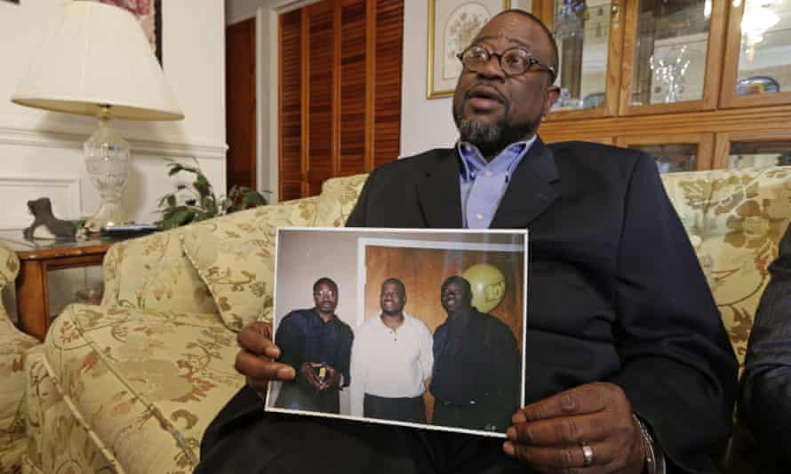 Anthony Scott holds a photo of himself and his brothers, with Walter Scott seen on the far left.