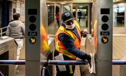 An MTA worker cleans turnstiles at the Times Square subway station.