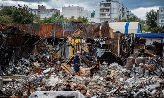 A man walks by a street market destroyed by military strikes in the residential area of ​​Saltivka in Kharkiv, Ukraine.
