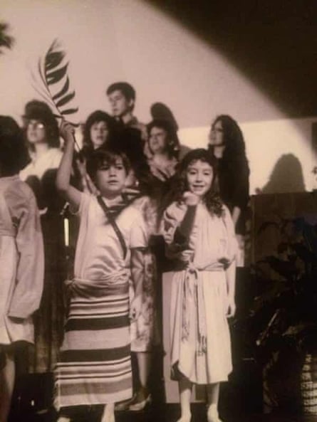 boy holds palm frond among other kids