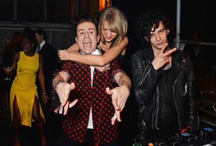 Matt Healy of band the 1975 with singer Taylor Swift and DJ Nick Grimshaw at the 2015 Brits party