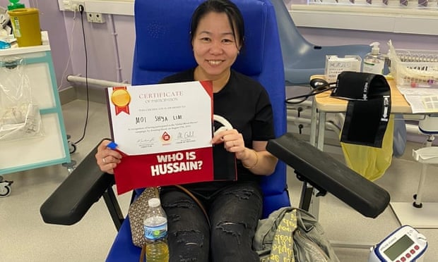 A donor shows off her certificate after giving blood in Birmingham