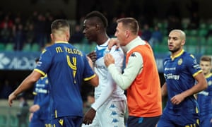 Brescia and Verona players try to prevent Mario Balotelli leaving the field following racist abuse from the crowd.