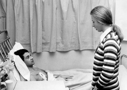 Princess Anne chatting to her bodyguard who is laying in a hospital bed
