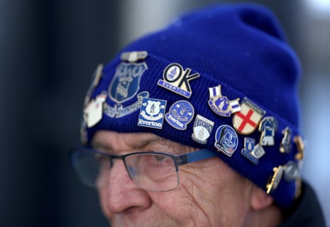 A detailed view of a hat decorated in Everton themed pin badges, worn by a fan outside the stadium