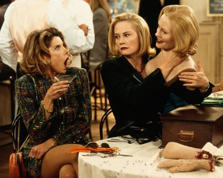 a woman looking shocked as another woman next to her holds a lifelike replica next to her head