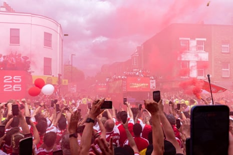 Arsenal Women Football Club bus at the Arsenal Champions Parade, celebrating winning the FIFA Women's Champions Cup 2026. Crowds of supporters in red smoke.