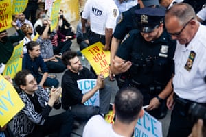 Immigration activists chant as police arrest people.