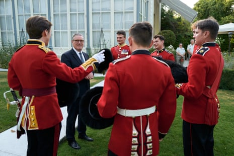 Starmer meeting with member of the British Army's Grenadier Guards at the British Residence ahead of the annual Bastille Day military parade in Paris this morning.