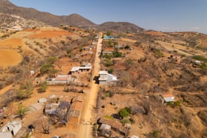 Aerial shot of scattered homes along a road in dry, sandy landscape