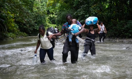 Haitian migrants wade through a river as they cross the Darién Gap in October 2022.