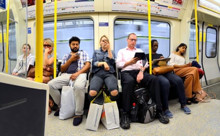 rail passengers look at their mobile phones