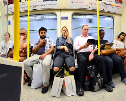 London, England, UK. People on the Tube / underground, all looking at mobile phones / iPads