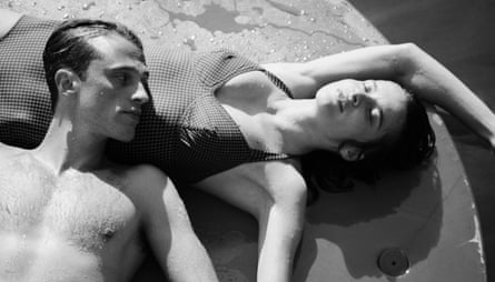 The two actors, shot in black and white, lie on a beach in their swimming costumes