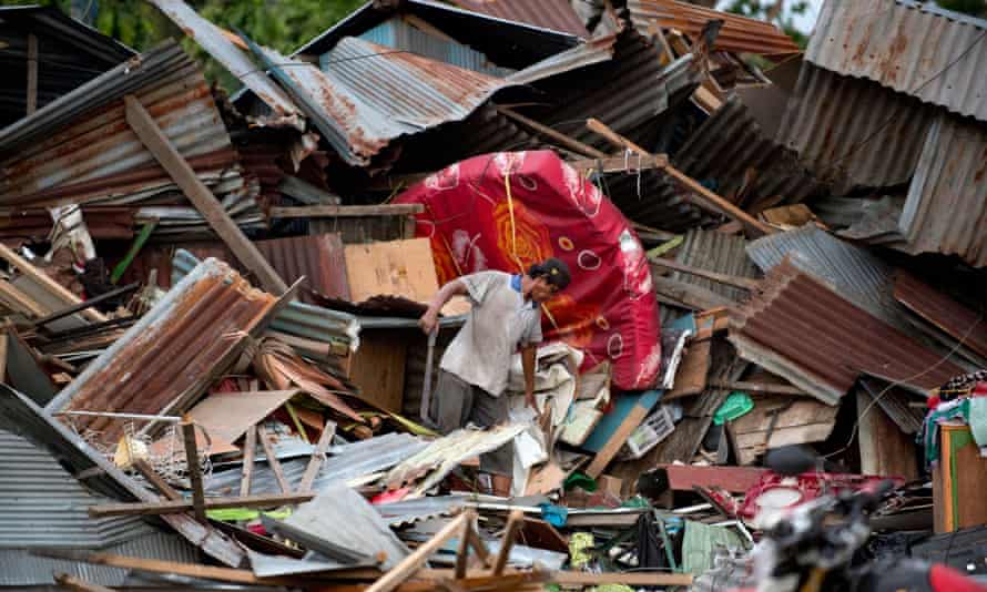 A man looks for his belongings amid the debris of his destroyed house in Palu.