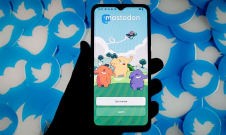 Mastodon being used on a smartphone with Twitter logos in the physical background